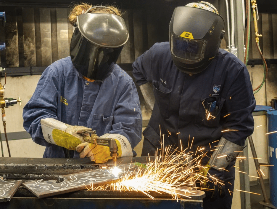 Grade 10 student, Tessa Nendsa,15, uses an acetylene torch to cut out a cat from a piece of steel under the watchful eye of advanced welding instructor Leah Applejohn as she takes part in the Jill of all Trades workshop to empower women and youth to explore skilled trades on Thursday, Nov. 27, 2025, at NAIT in Edmonton. About 200 students from grades 9-12 including a group from Yellowknife are taking part in workshops including, electrician, ironworker, powerline technician, plumber and welder. Photo by Greg Southam /Postmedia